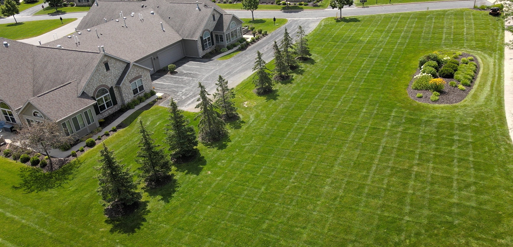 Aerial view of landscaped lawn and homes