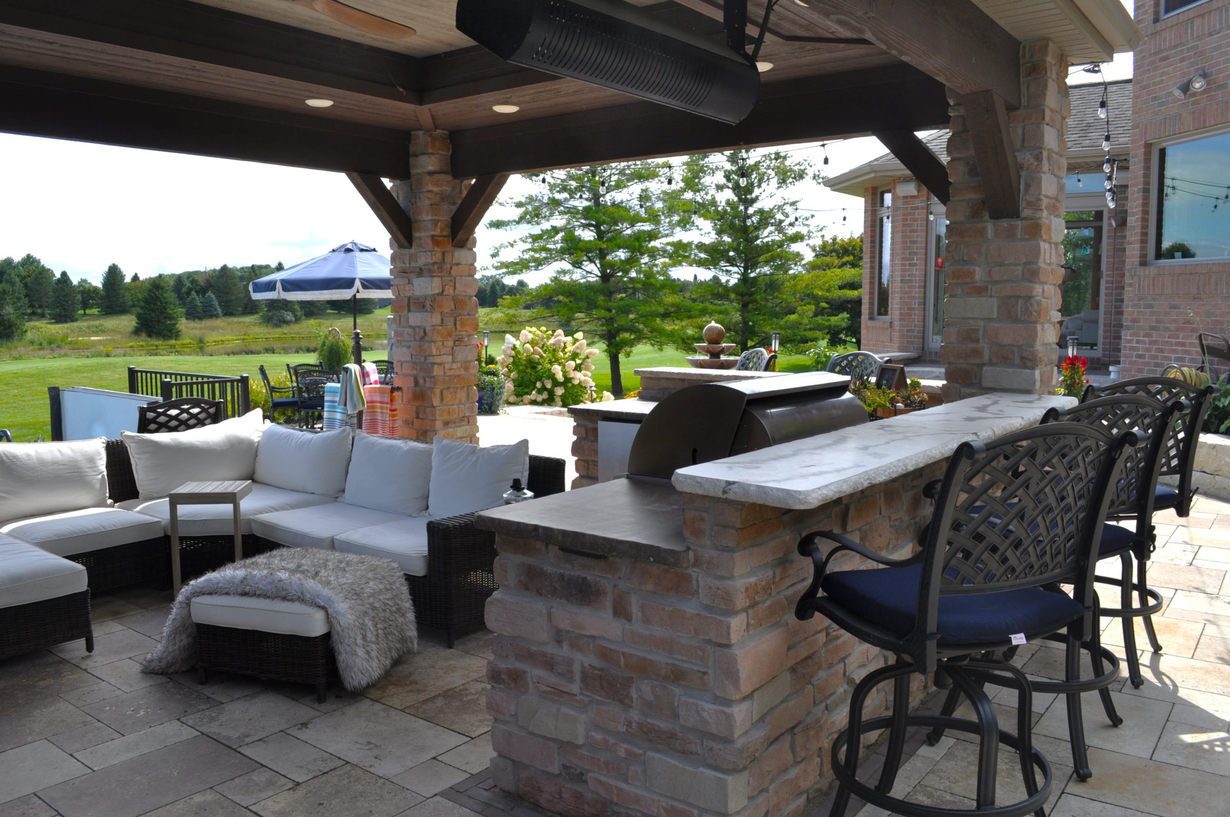 Covered outdoor patio with kitchen and seating area