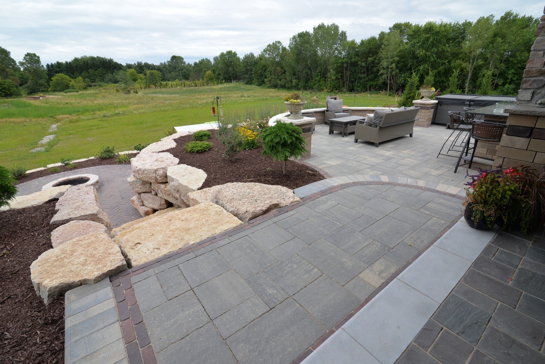 Landscaped backyard patio with seating and stone fire pit