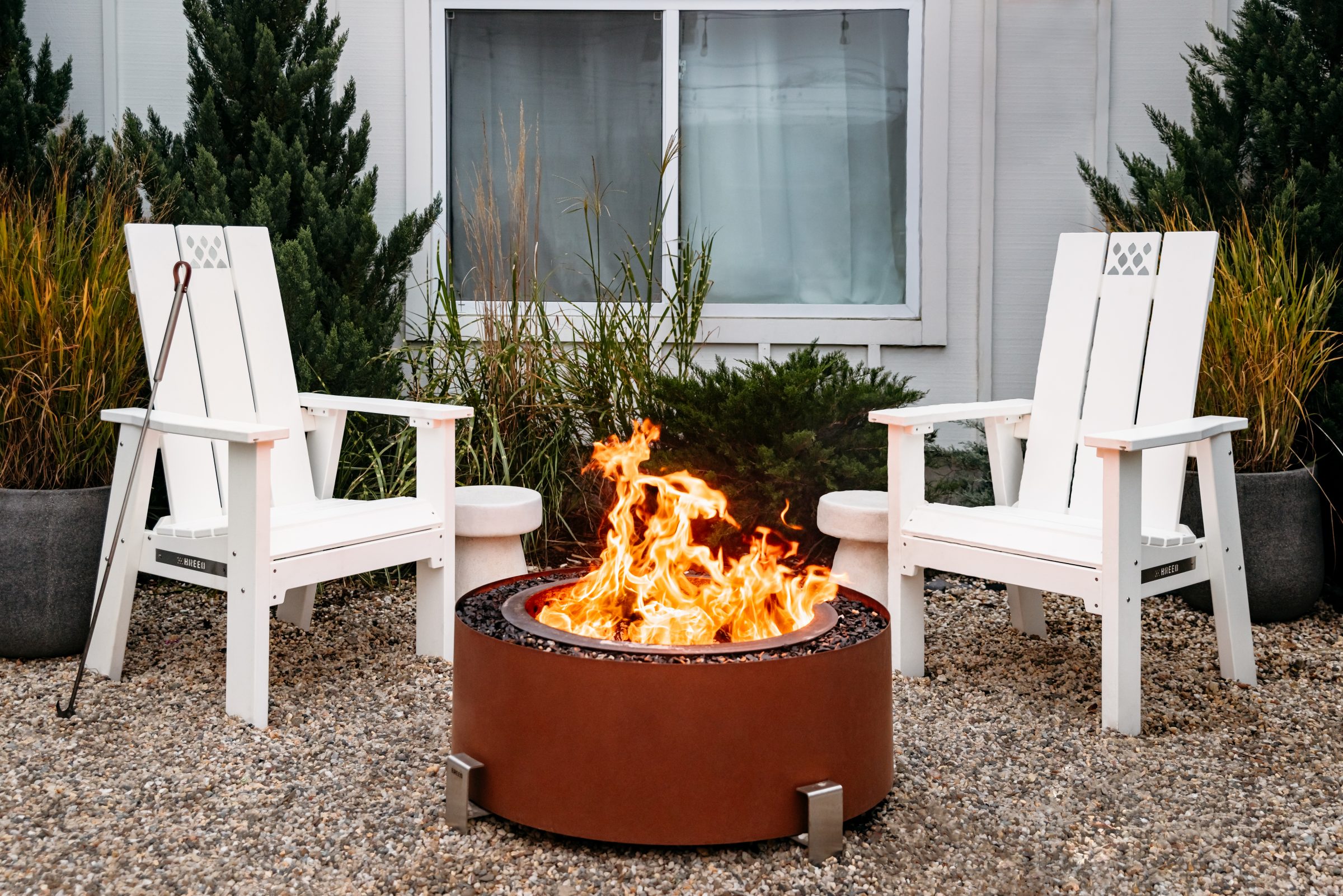 Two white chairs around outdoor fire pit