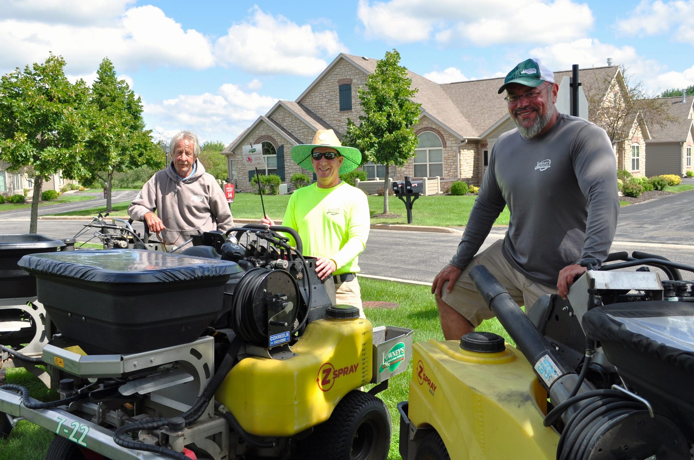 Lawn care workers with equipment in neighborhood