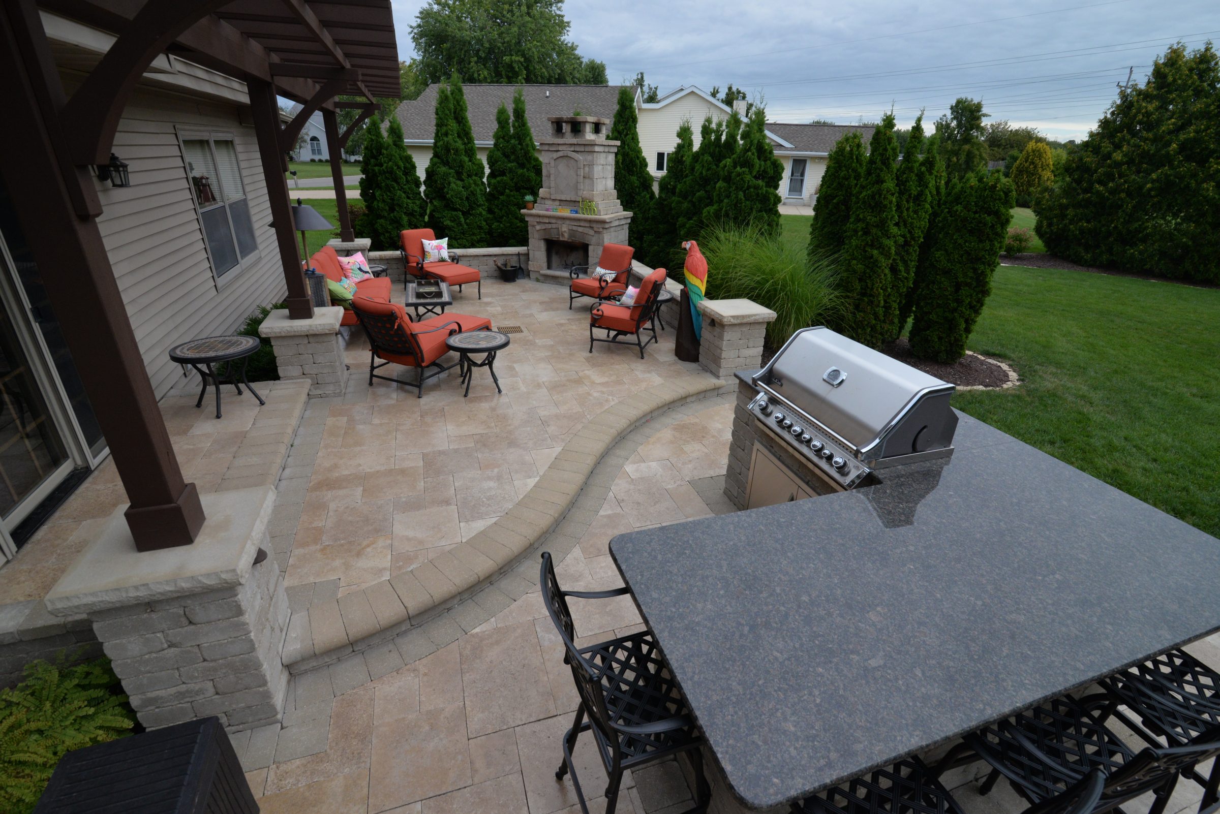 Backyard patio with fireplace, grill, and seating