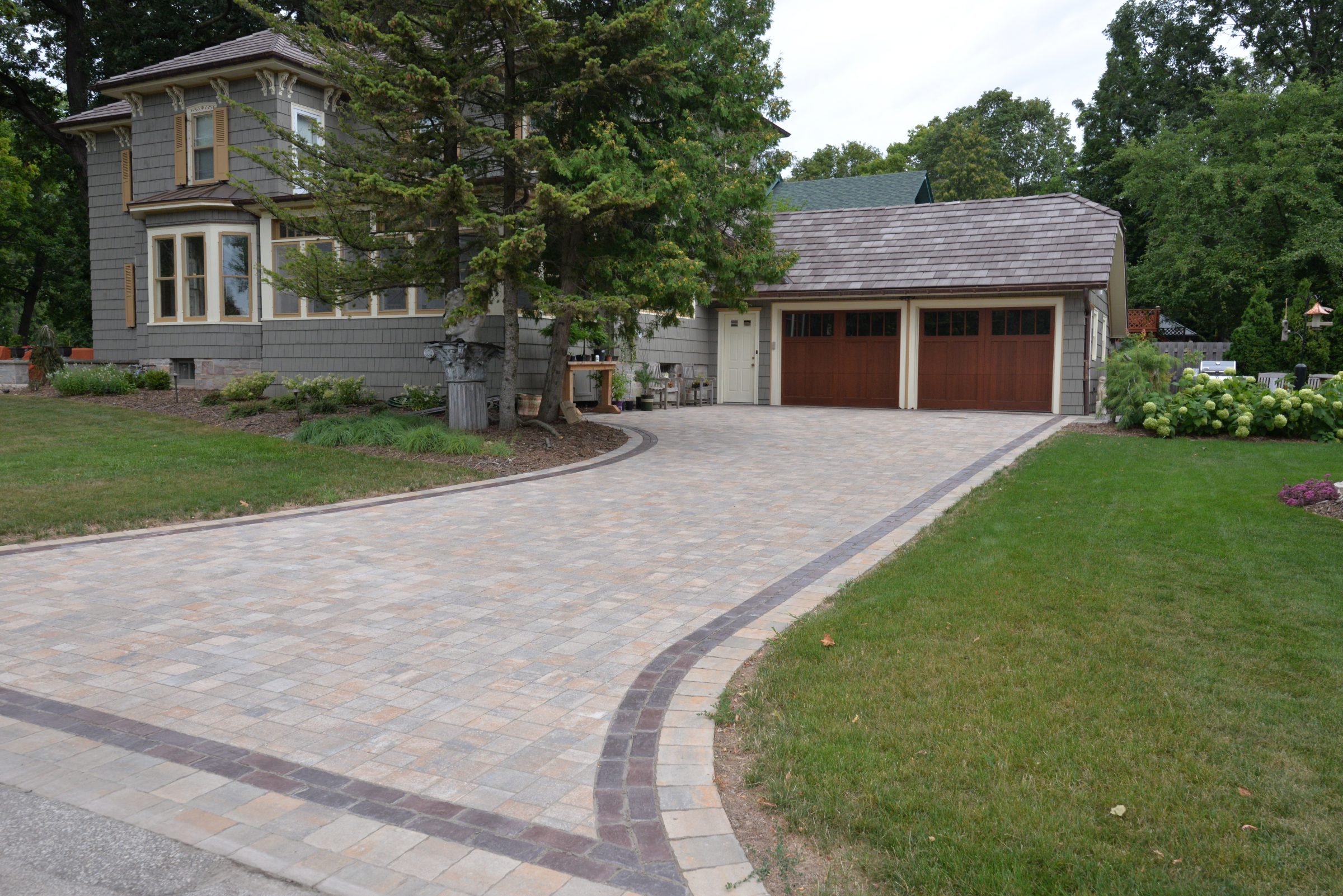 Gray suburban home with curved paved driveway