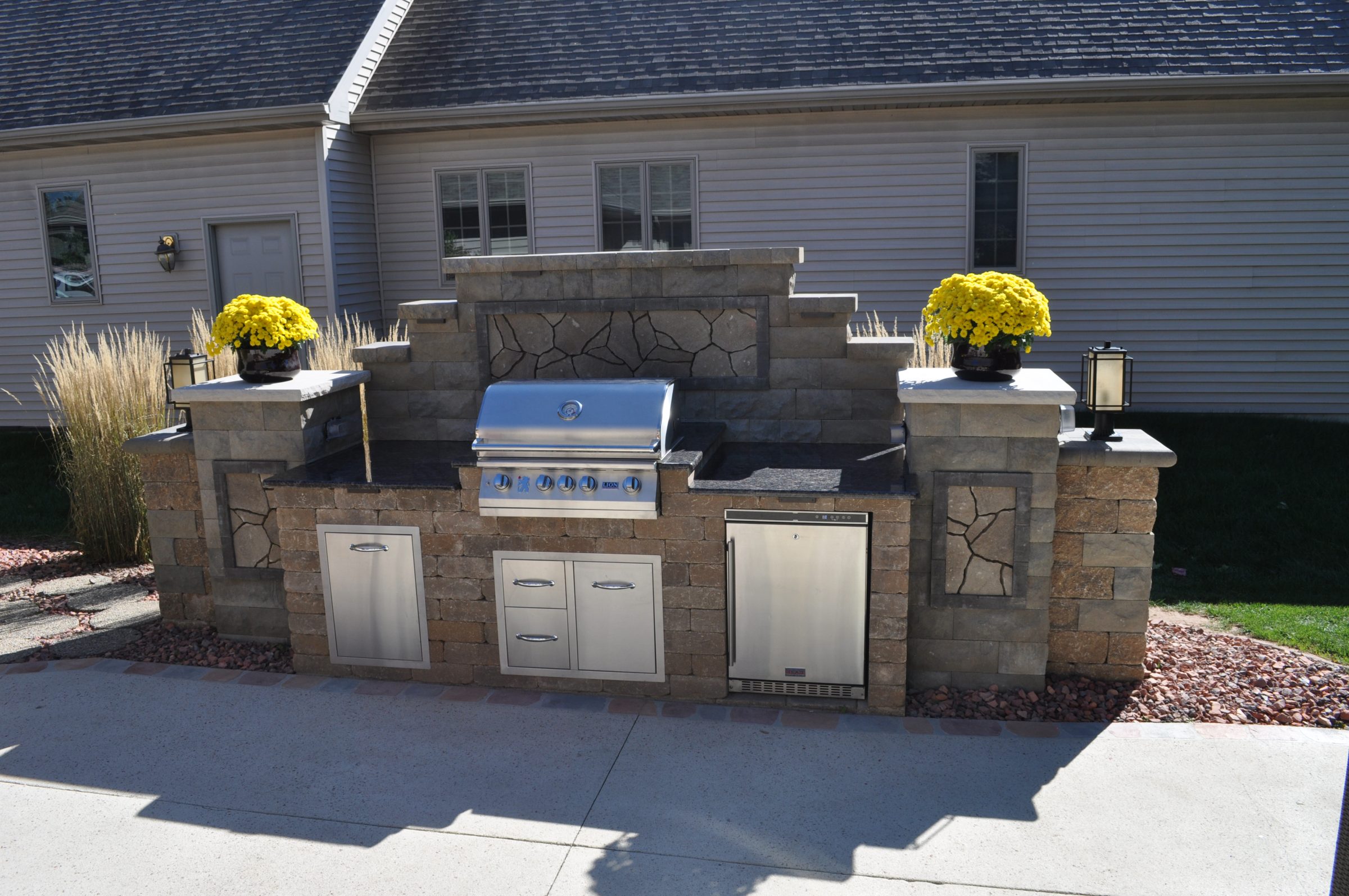 Stone outdoor kitchen with built-in grill and cabinets