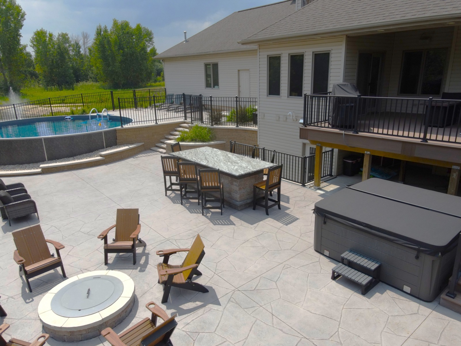Spacious backyard patio with pool and hot tub