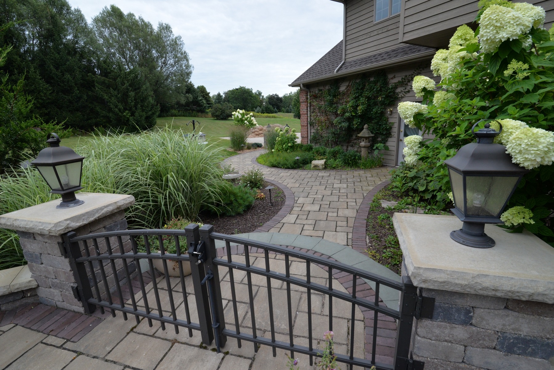 Landscaped garden entrance with iron gate and walkway