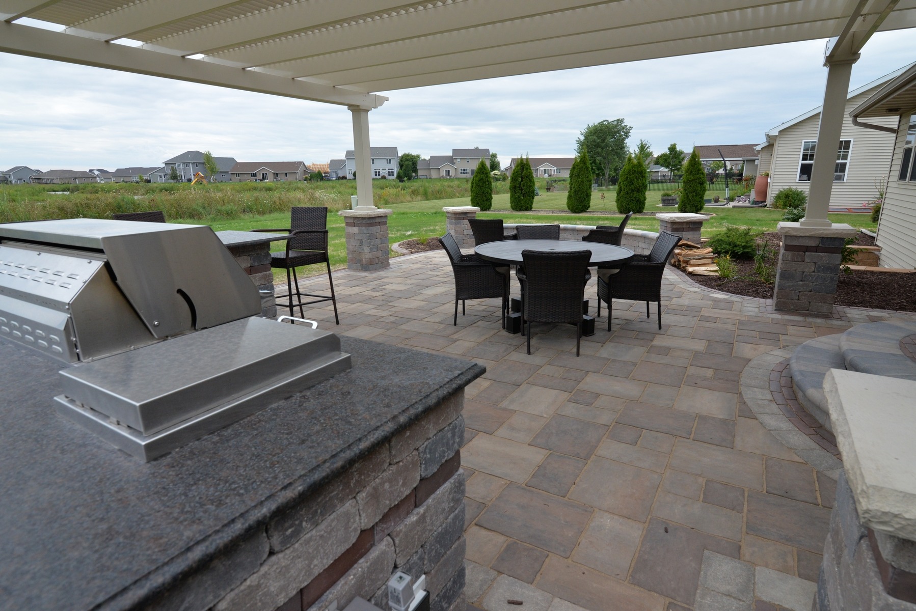 Covered backyard patio with grill and dining set