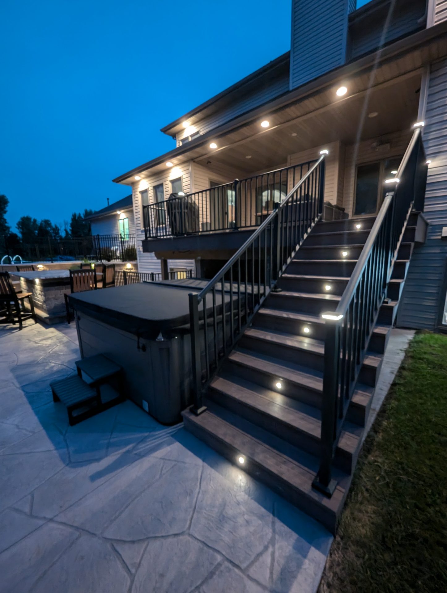 Illuminated backyard deck and stairs at dusk
