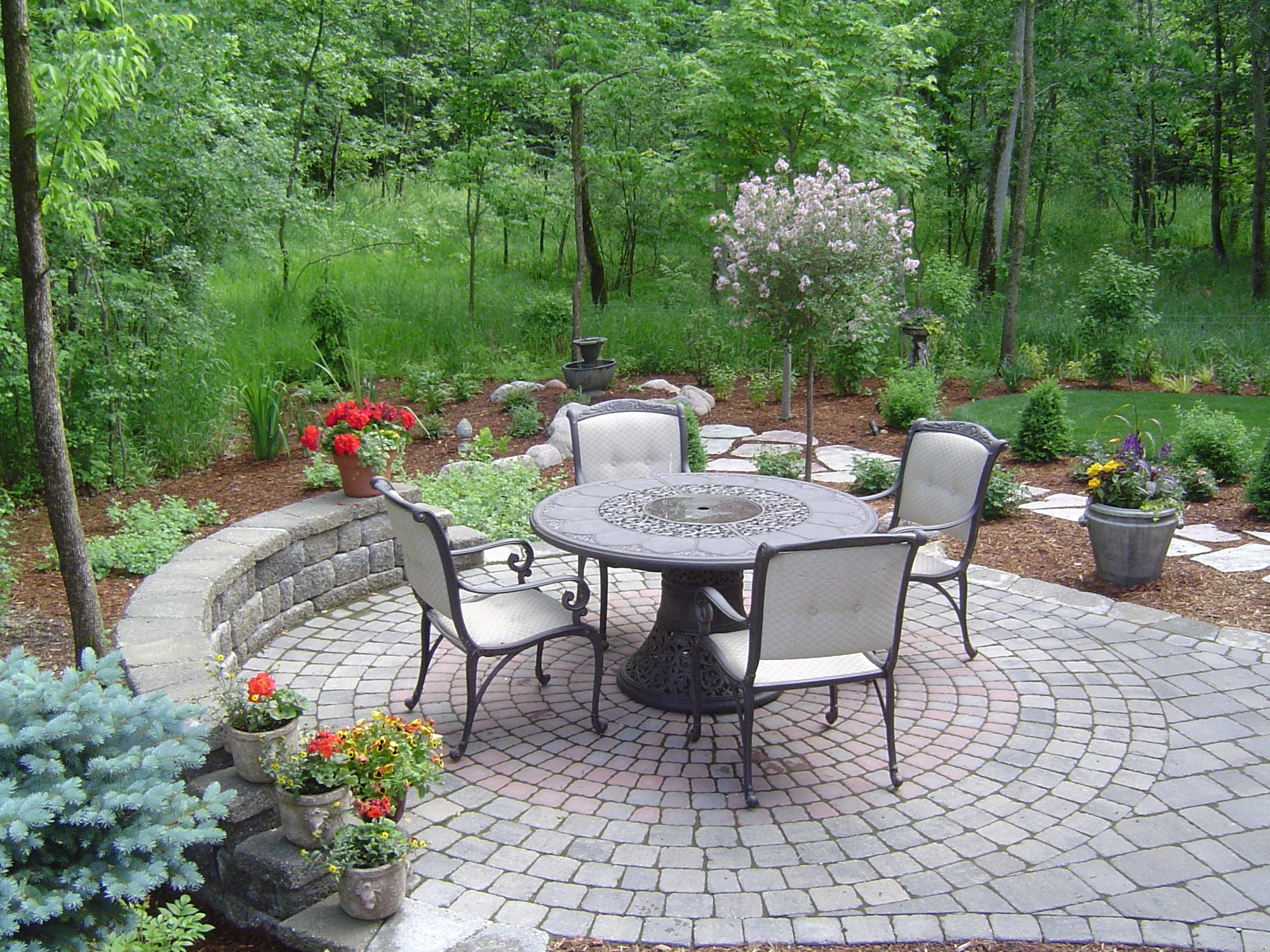 Stone patio with table and chairs in garden