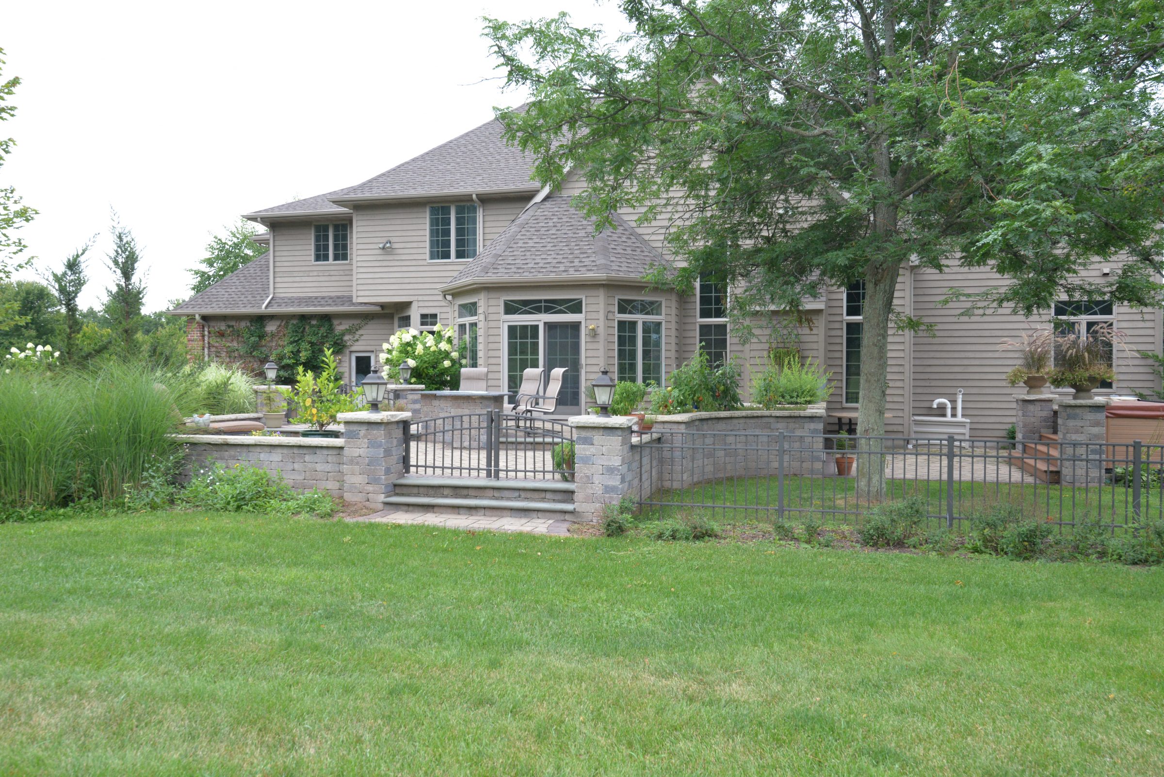 Large suburban home with landscaped backyard patio