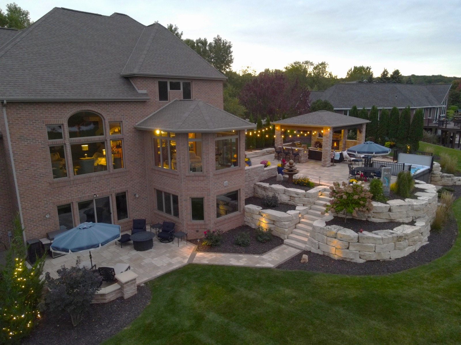 Luxury brick home with tiered backyard patio