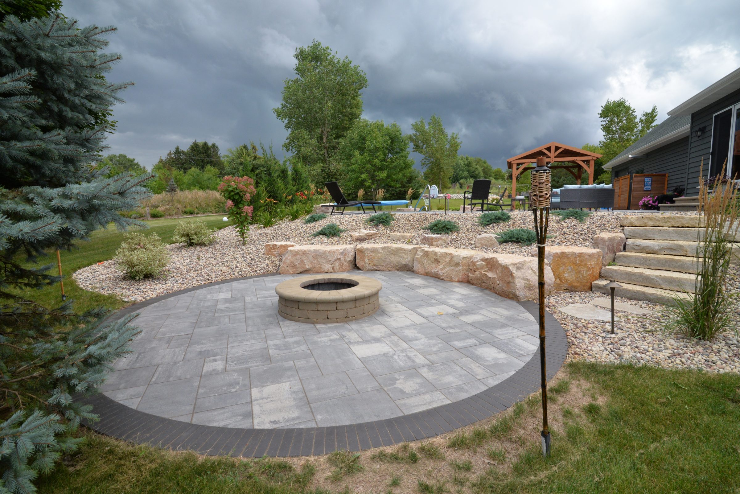Backyard patio with circular fire pit and gazebo