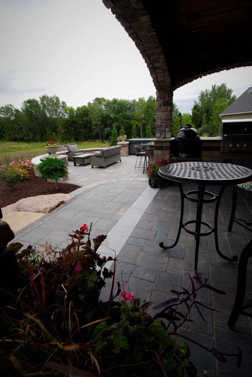 Covered backyard patio with outdoor kitchen and seating