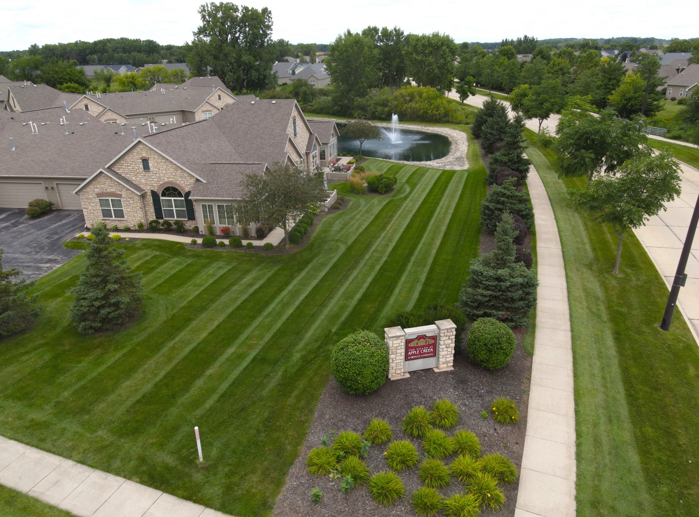 Aerial view of suburban homes with pond fountain