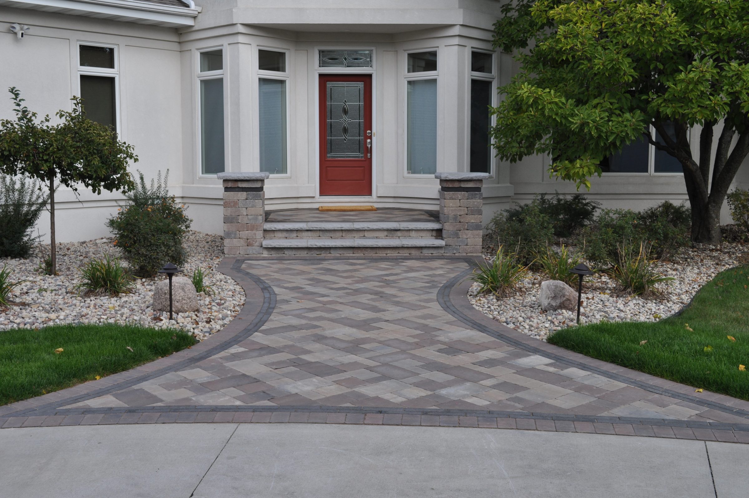 Red front door with landscaped stone walkway