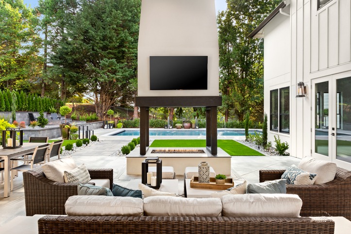 Luxury backyard patio with fireplace, TV, and pool