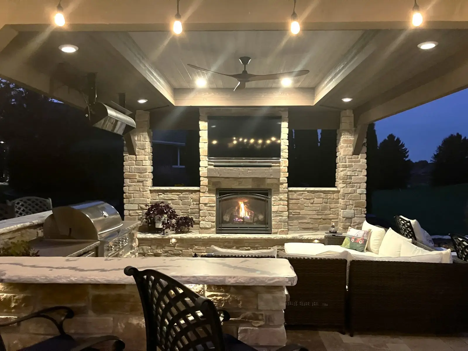 Cozy outdoor patio with fireplace and TV