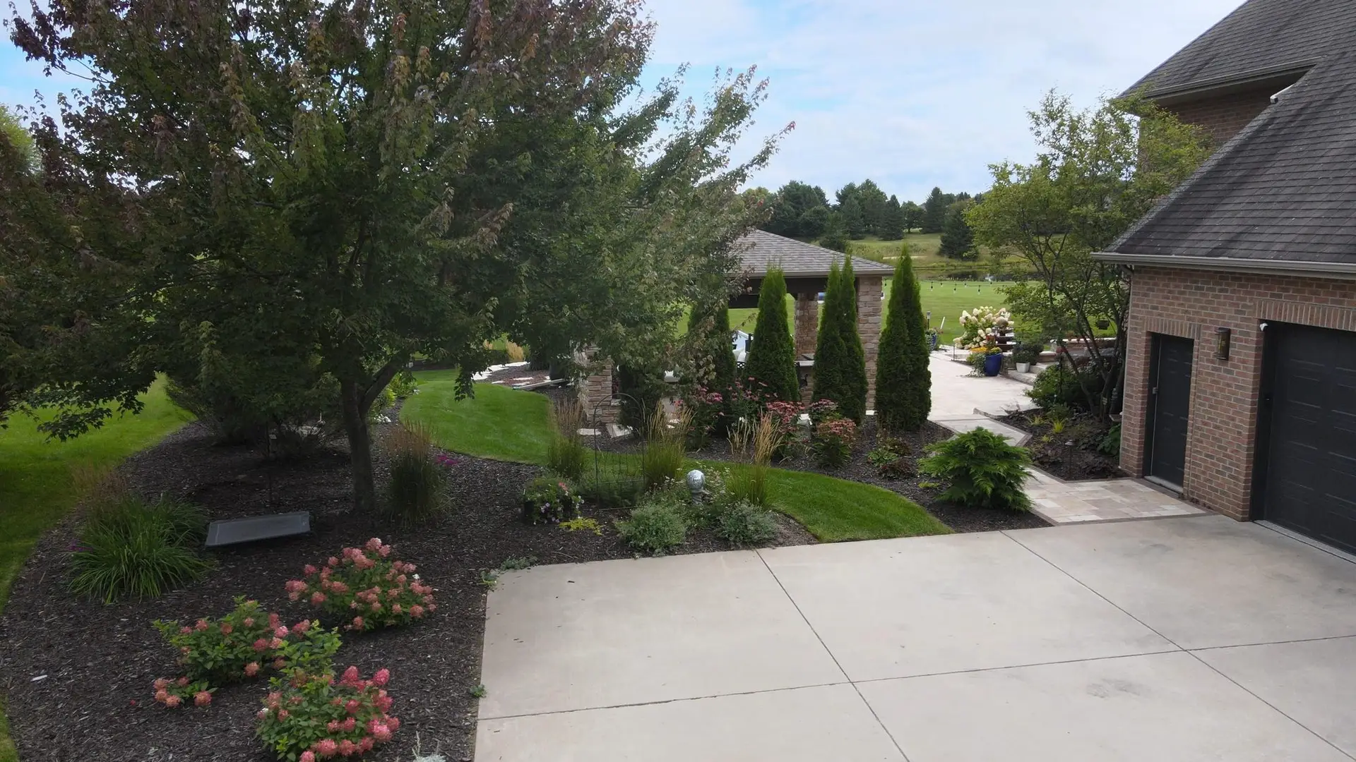 Landscaped backyard with patio overlooking golf course