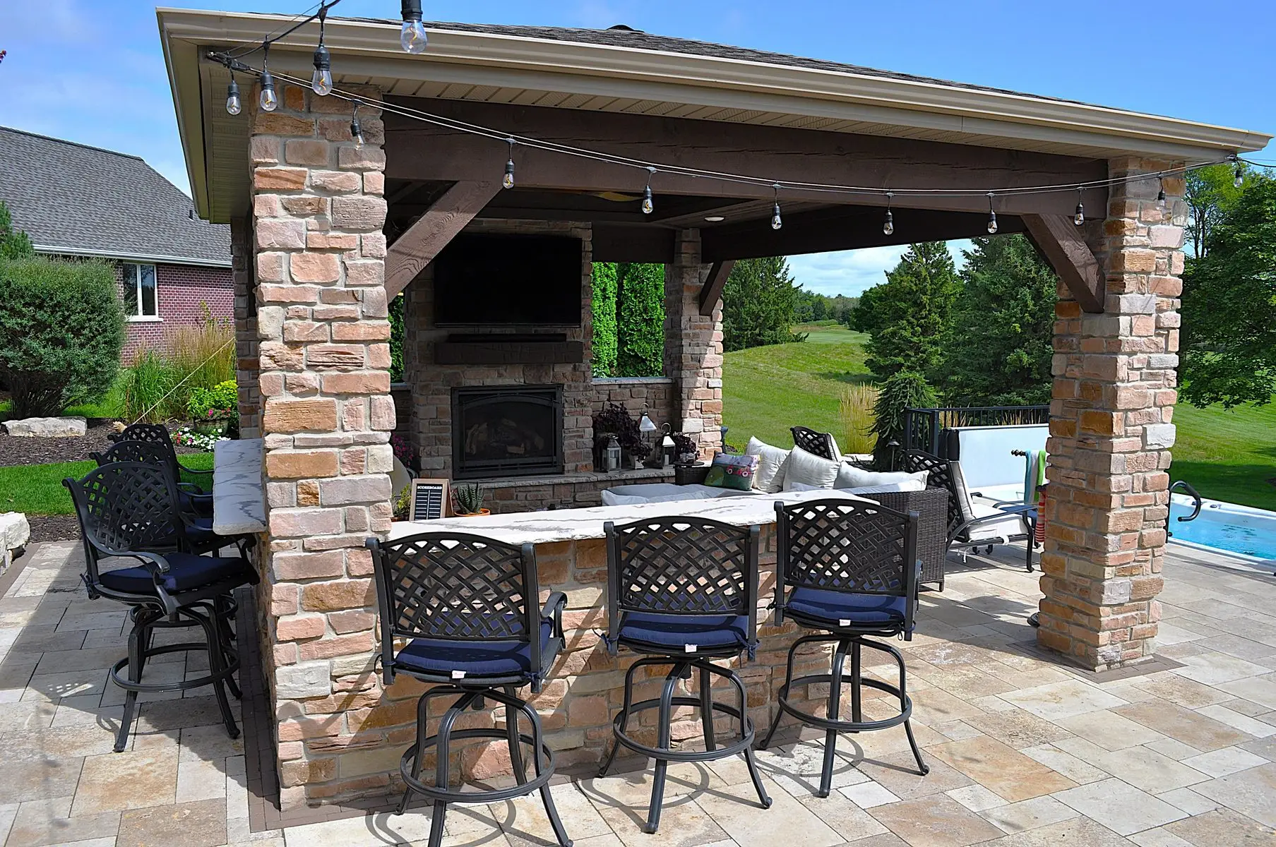 Outdoor stone patio pavilion with bar and fireplace