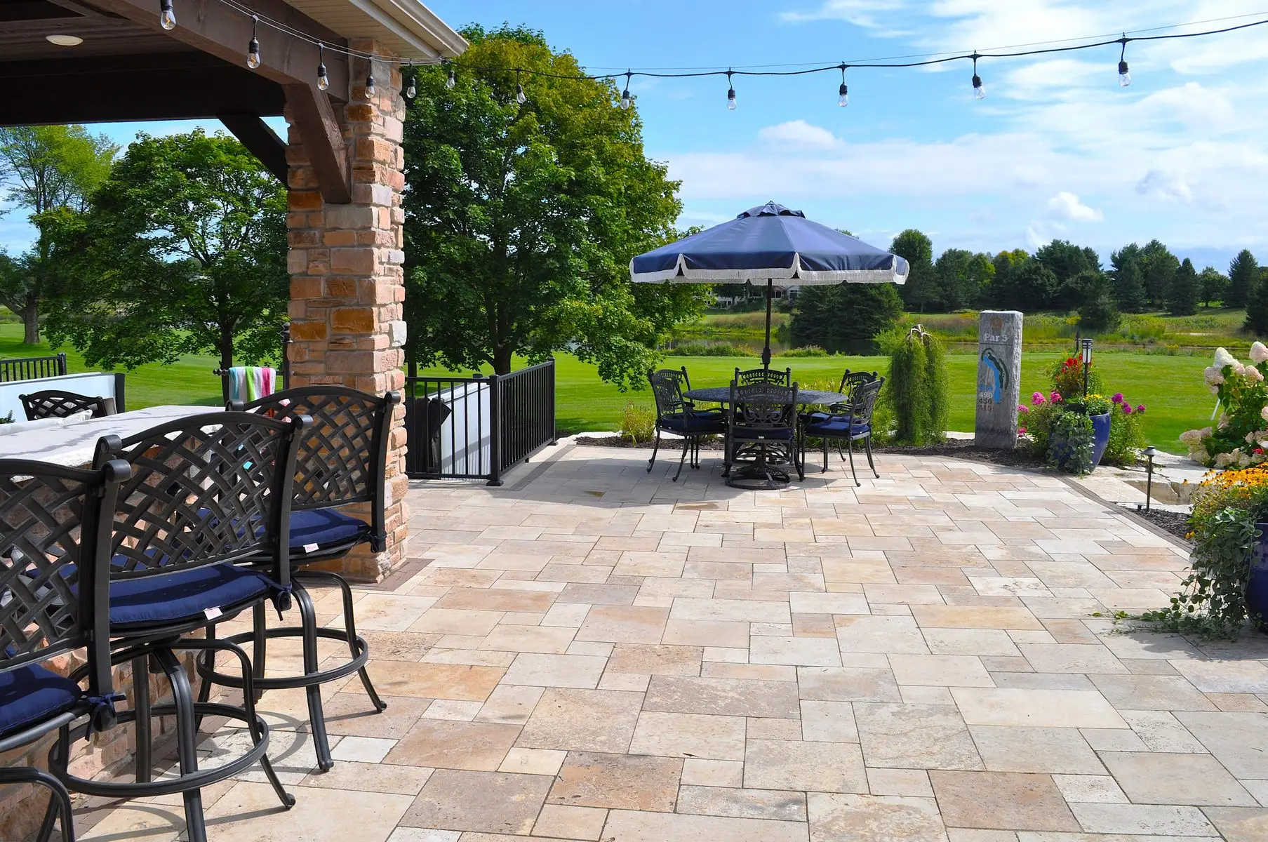 Spacious stone patio with umbrella and golf course view