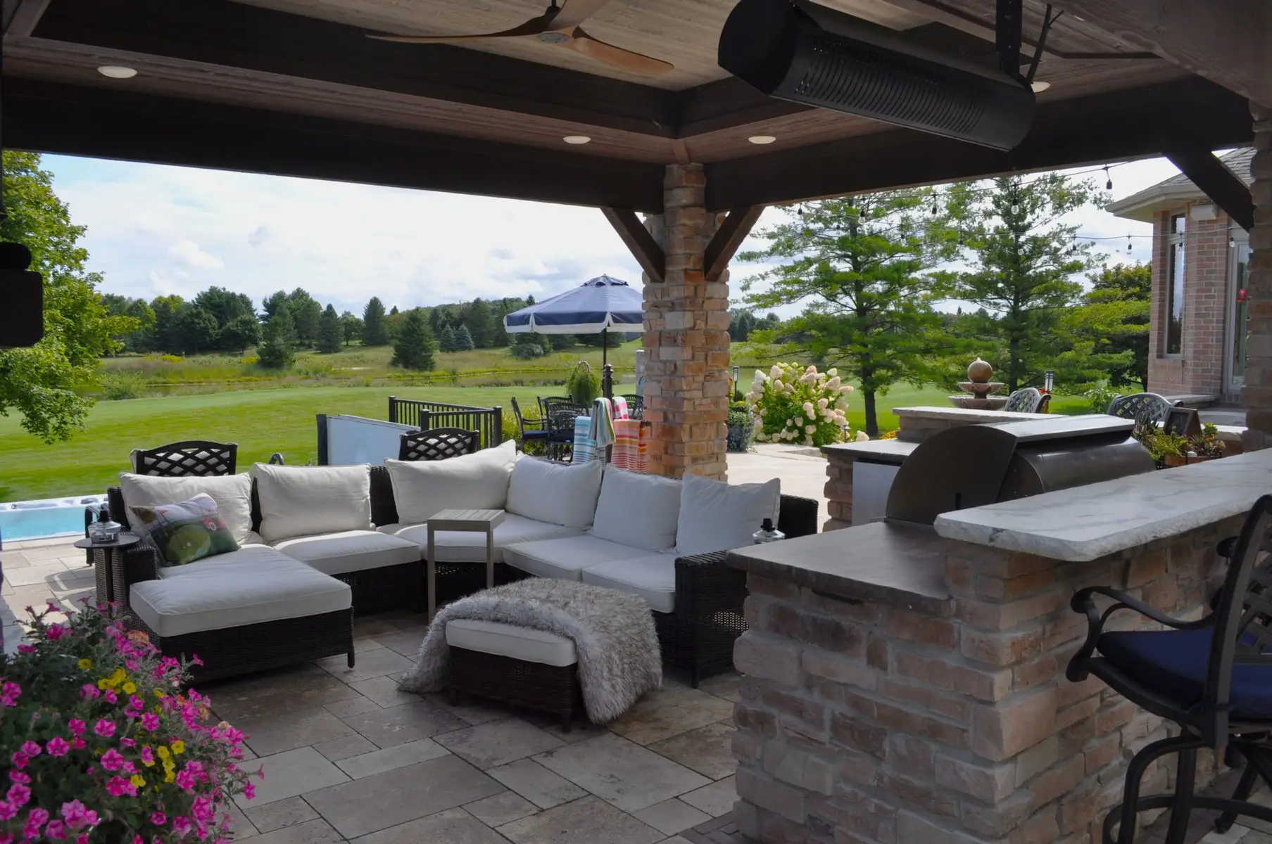 Covered backyard patio with outdoor kitchen and seating