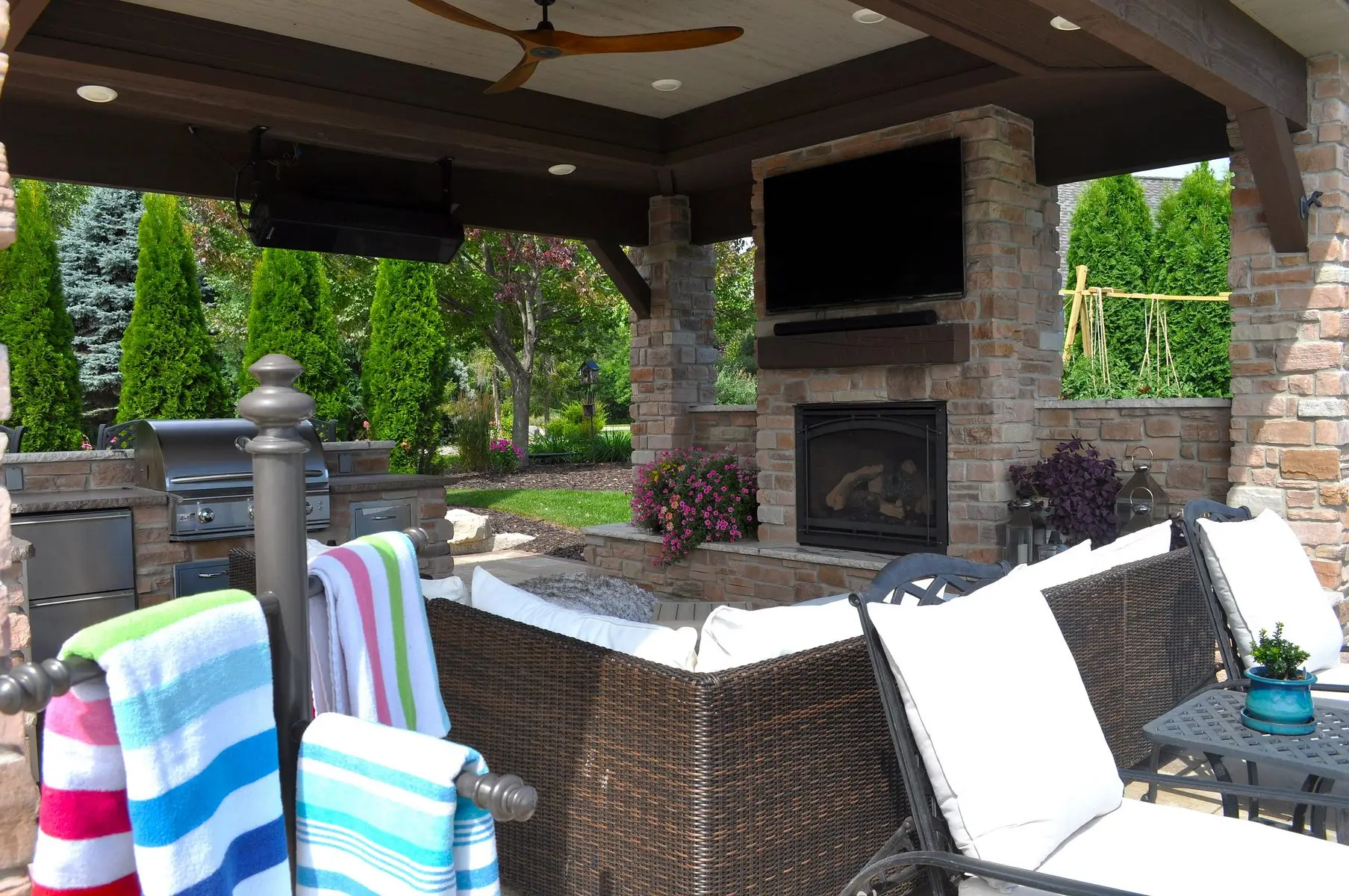 Covered outdoor patio with fireplace and grill
