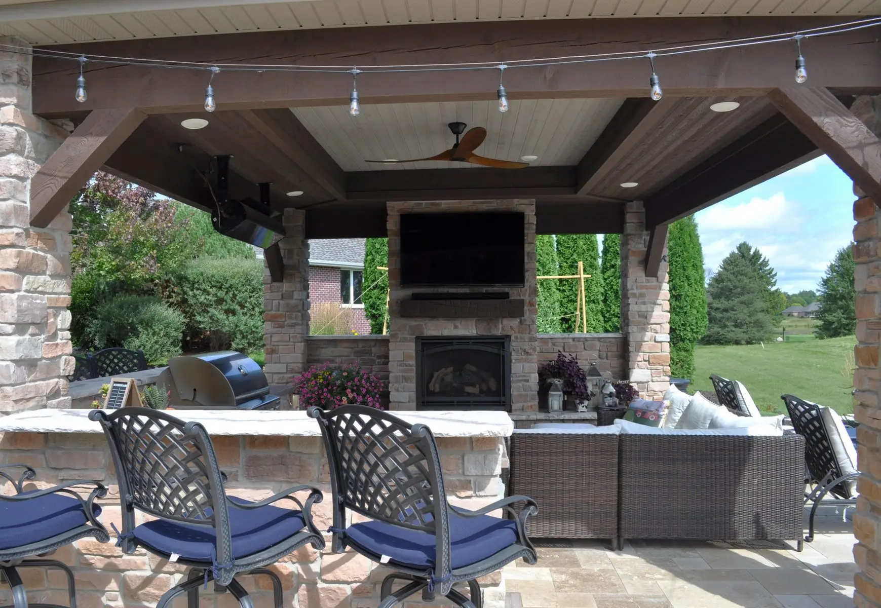 Covered outdoor patio with fireplace and seating