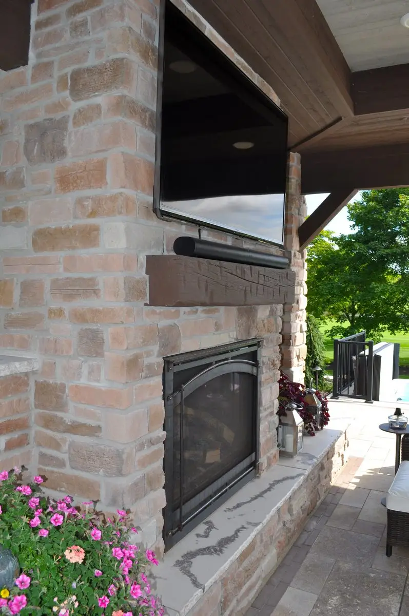 Outdoor brick fireplace with mounted TV