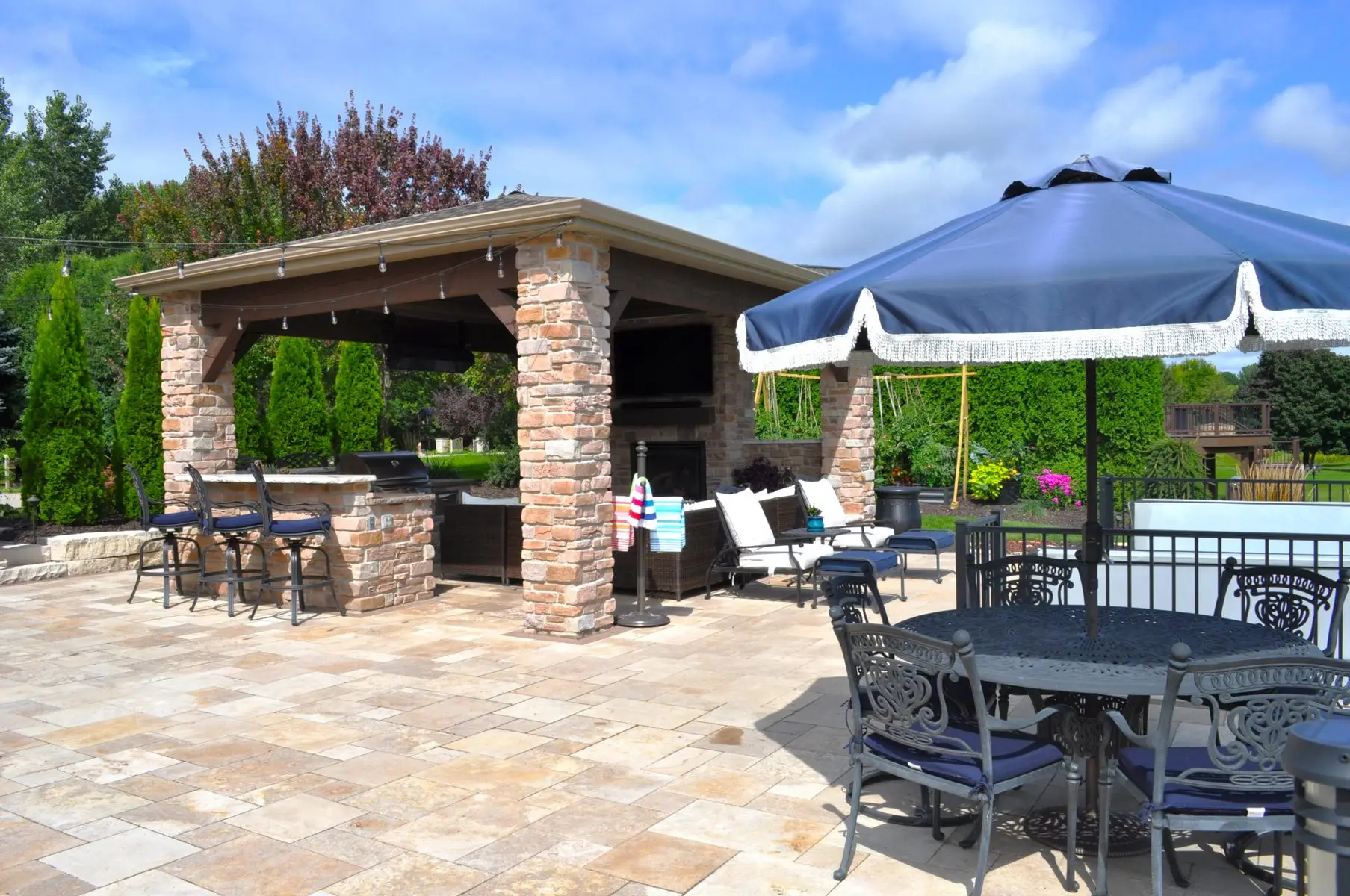 Backyard patio with stone outdoor kitchen and seating