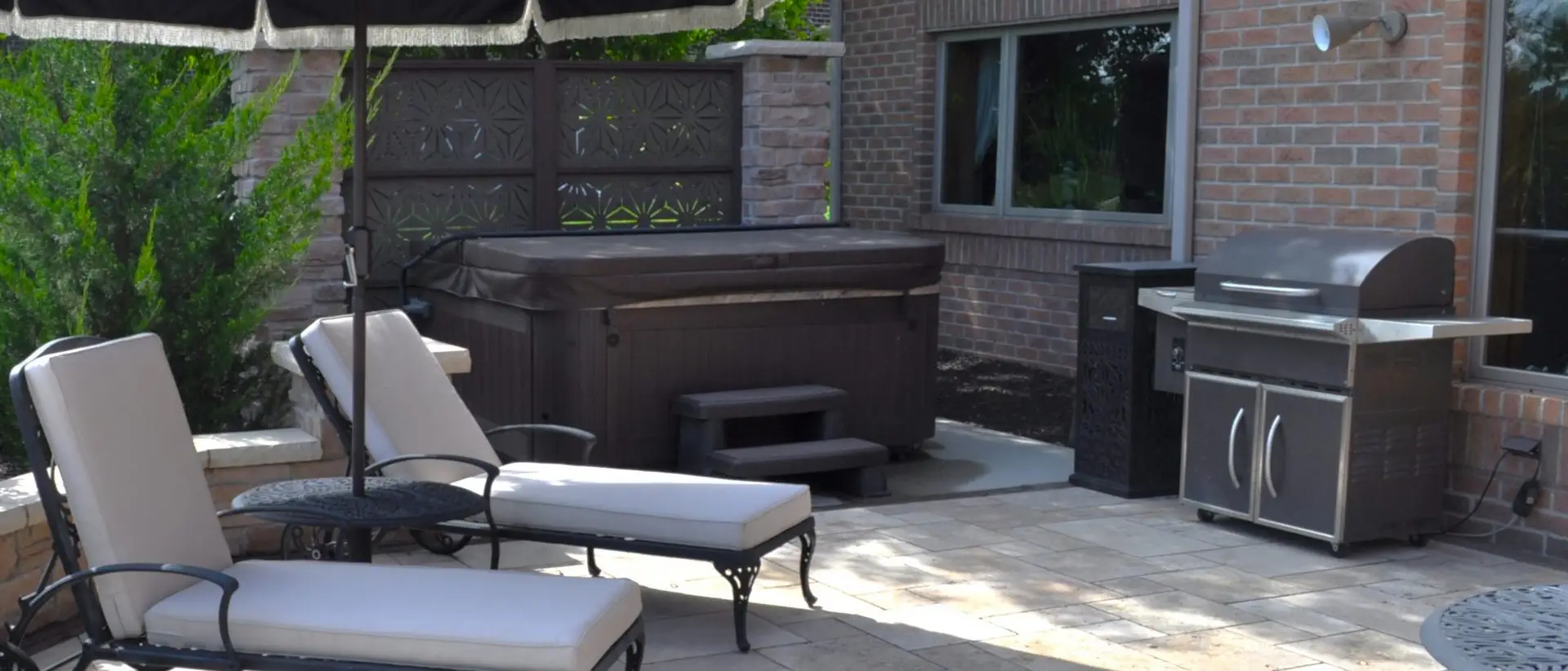 Backyard patio with hot tub and grill