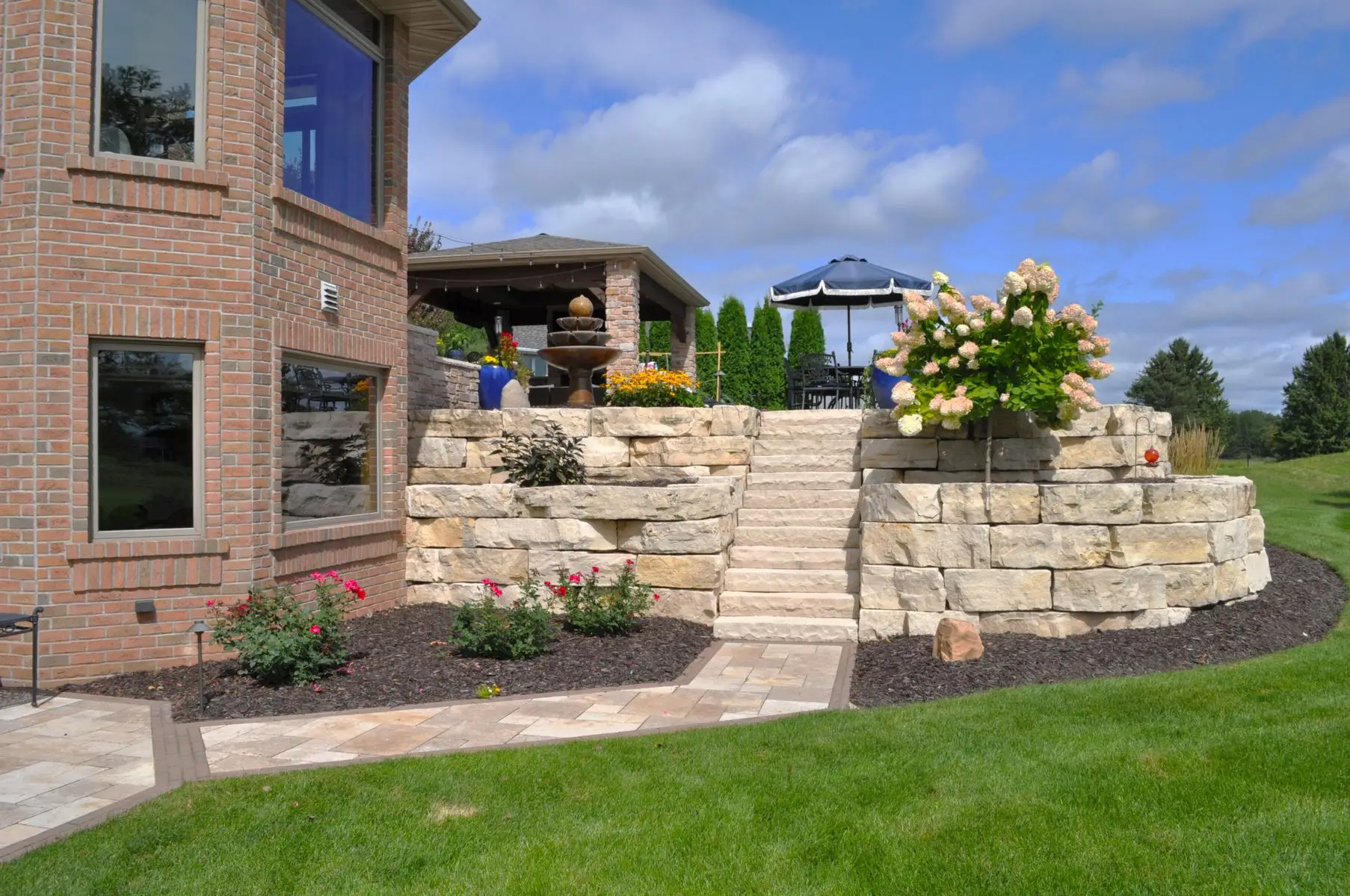 Backyard patio with stone retaining wall and steps