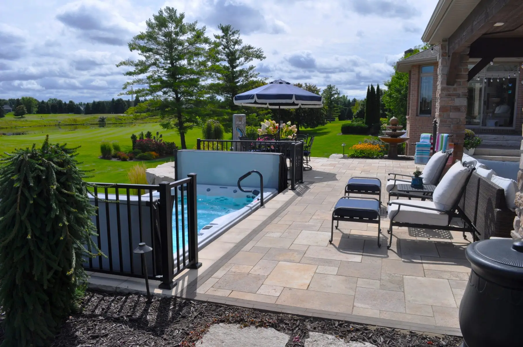 Backyard patio with hot tub and lounge chairs